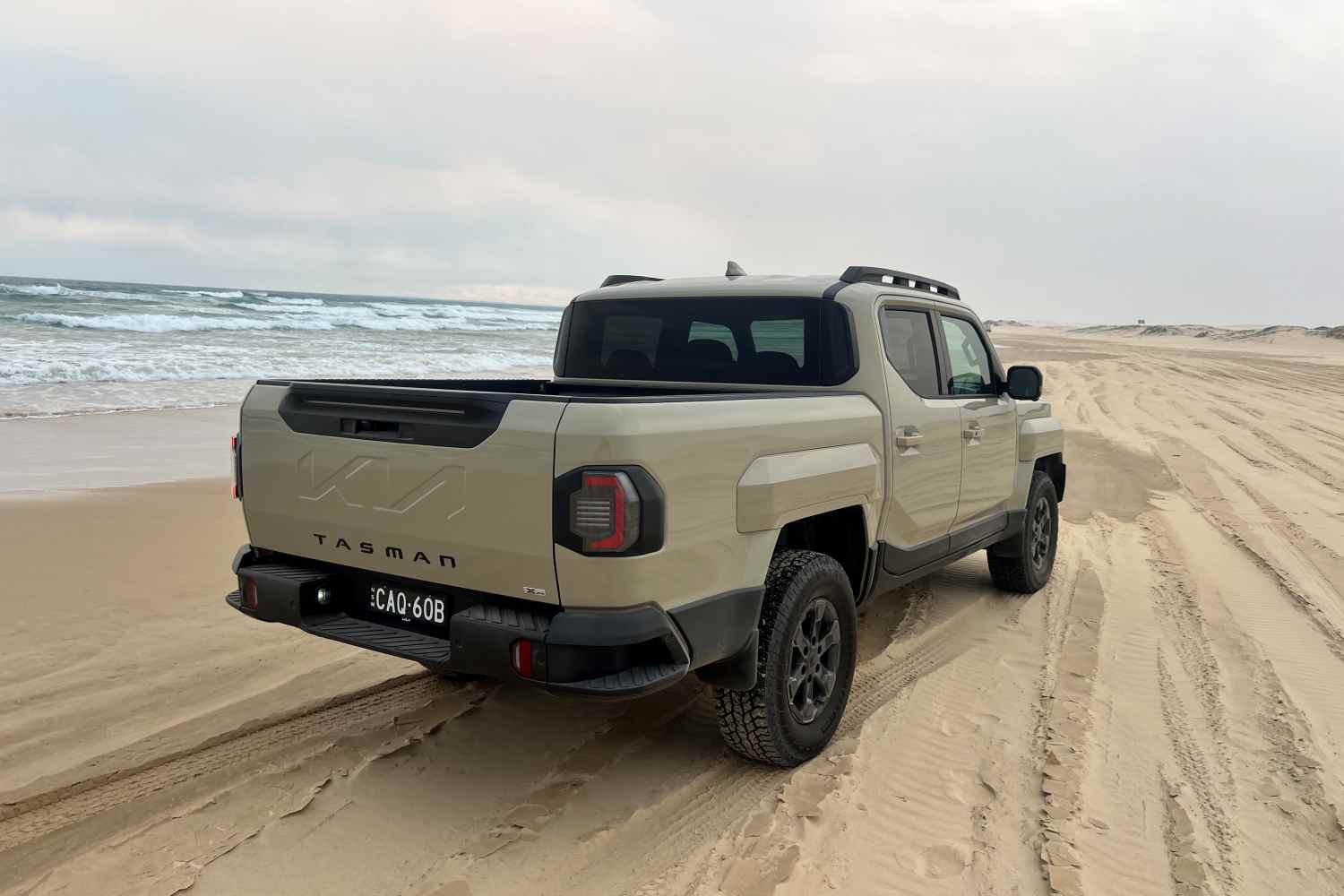 Kia Tasman X-Pro 4WD Ute rear quarter on beach 1