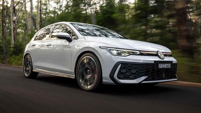2026 VW Golf GTi front quarter driving view 1