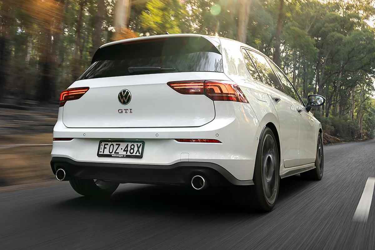 2026 VW Golf GTi rear quarter driving view 1