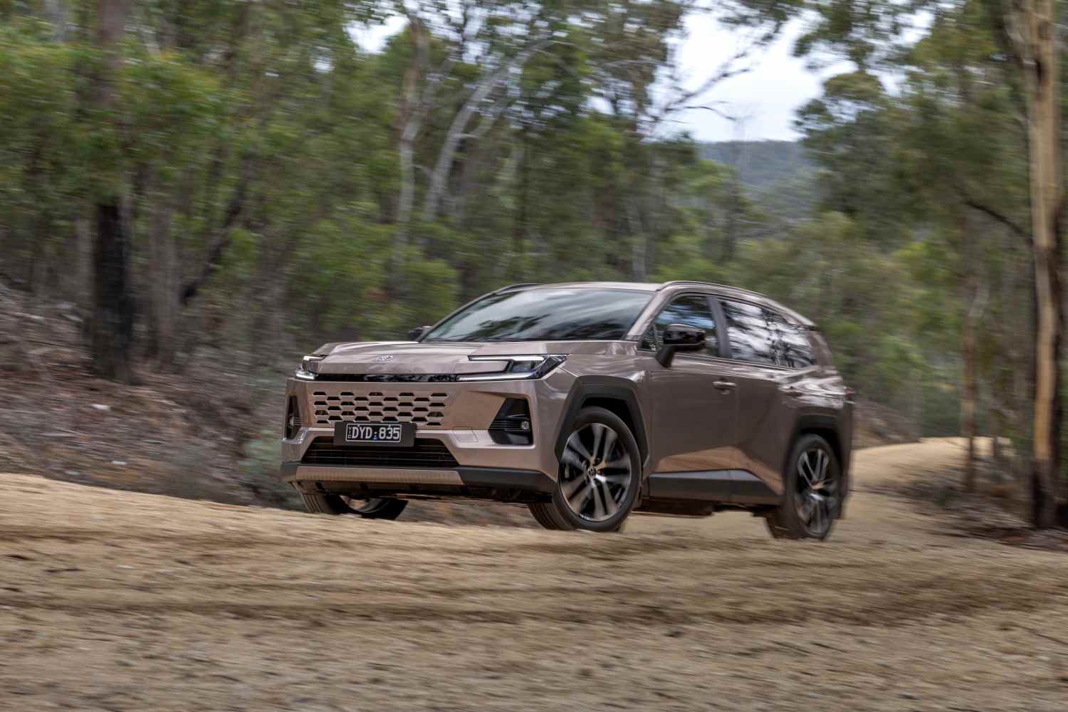 2026 Toyota RAV4 Cruiser AWD Hybrid front driving on dirt road 2